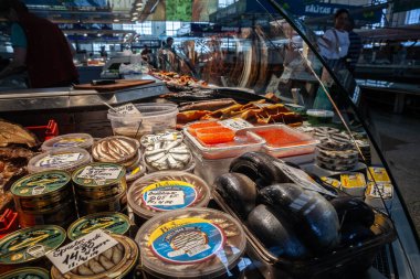 RIGA, LATVIA - 21 AĞUSTOS 2023: Baltık deniz ürünlerinde seçici bulanıklık: tütsülenmiş balık, sprat, bir balıkçıda satılık havyar, Centraltirgus, Riga Central pazarında balık tüccarı.