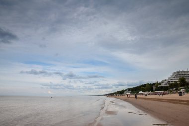 JURMALA, LATVIA - 20 AĞUSTOS 2023: Dubulti 'deki Jurmala plajında (Jurmalas Pludmale), Baltık Denizi' nde, yağmurlu bir öğleden sonra. Jurmala, Letonya 'nın Baltık devletlerinde bir tatil beldesidir..