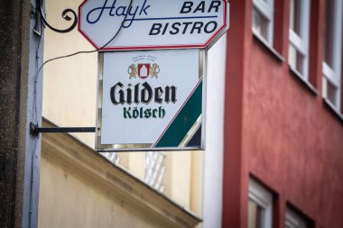 COLOGNE, GERMANY - NOVEMBER 12, 2022: Selective blur on a Gilden Kolsch Beer logo on a local retailer. Gilden is a Kolsch beer, a traditional beer from the Cologne Region. clipart