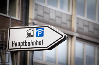 Hauptbahnhof 'a giden yolu gösteren bir yol işaretinde seçici bulanıklık, yani Almanca ana tren istasyonu, Aachen Hbf, demiryolu ve diğer ulaşım araçları için çoklu modül taşıma merkezi..