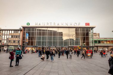 KOLOGNE, GERMANY - 6 NOVEMBER 2022: Köln Hbf 'ün ana cephesi, veya Köln Ana Tren İstasyonu (Hauptbahnhof) alacakaranlıkta yolcuların aceleyle koştuğu ana tren istasyonu..