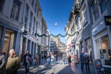 Maastricht, Netherlands - November 10, 2022: Panorama of Kleine Staat street in Maastricht city center, a pedestrian street surrounded by shops and stores. clipart