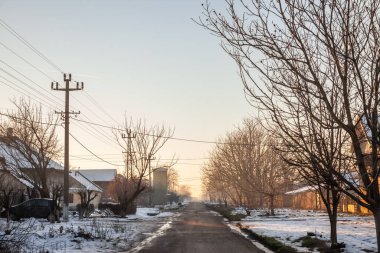 Voyvodina, Banat, Sırbistan 'ın kırsal kesimindeki crepaja köyündeki bir yol ve sokak panoraması, kış mevsiminin soğuk ve dondurucu bir öğleden sonrasında çok kar yağışıyla.