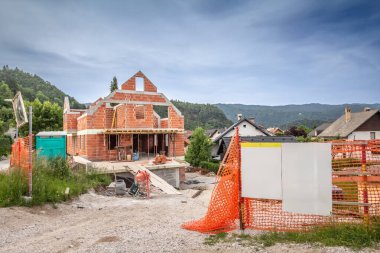 Slovenya 'nın kenar mahallelerinden birinde, emlak sektörünün patlama yaşadığı Slovenya Alplerinde, tek bir aile evinin inşaat alanına giriş..