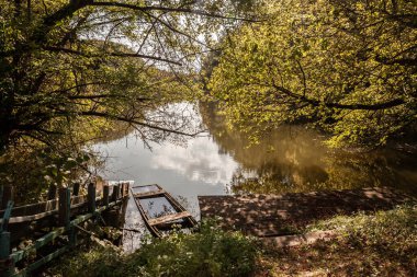 Macaristan 'ın Mohacs kentindeki Duna Drava Nemzeti Parkı' nda, Hungary 'deki Danube nehrinin kıyısında ahşap bir rıhtım ve batmış eski bir kayık. Danube & drava nehirlerinin yanındaki Macar Milli Parkı..
