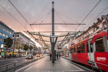 BONN, ALMANY - 7 Kasım 2022: Şenlikli şehir tramvayı alacakaranlıkta kalkmak üzere. Strassenbahn Bonn olarak adlandırılan, SWB tarafından işletilen, bonn içinde toplu taşımanın önemli bir bileşeni..
