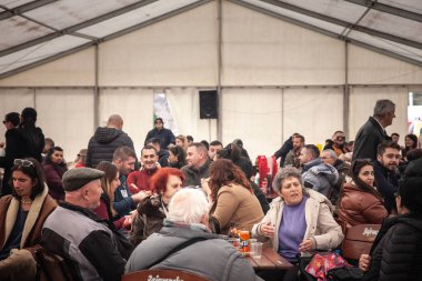 KACAREVO, SERBIA - 18 Şubat 2024: Sırp halkı hakkında seçici bulanıklık, çoğunlukla yaşlılar, Kacarevo 'da geleneksel bir Sırp kasabası olan kafana' da birlikte oturup içki içiyorlar..