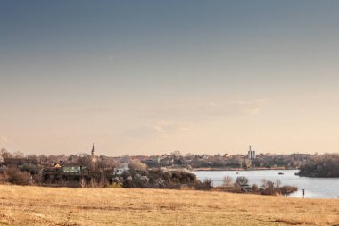 Panorama of the Village of Deliblato in Serbia with lake kraljevac in front at dusk. Deliblato is a serbian village of vojvodina known for its natural reserve, deliblatska pescara. clipart