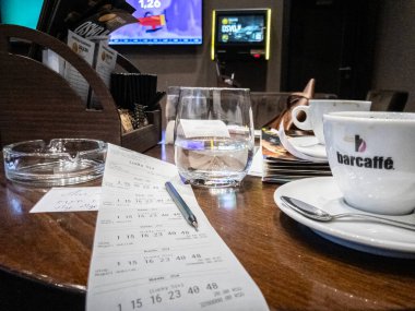 BELGRAD, SERBIA - 21 Mayıs 2024: Bir kladionica 'da kumar bileti, bir Sırp kumarhanesi, televizyon ekranları önünde spor gösteriliyor, insanlar bahislere ve kumara bahis oynuyor.