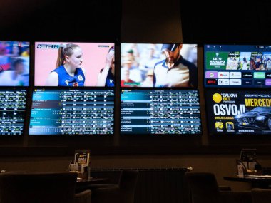 BELGRADE, SERBIA - MAY 21, 2024: Screens Displaying Matches, scores, scoreboards and Quotes in Serbian Kladionica, a bakan bookmaker or gambling house or betting house. clipart