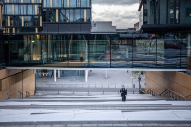 AÇİN, ALMANY - 8 Kasım 2022: adam Aachen 'deki Aachenmunchener karargahının merdivenlerine tırmanıyor. Modern mimarinin ve kentsel tasarımın bir simgesidir..