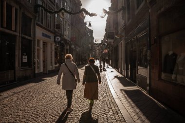 MAASTRICHT, NETHERLANDS - 10 Kasım 2022: Yaşlı Wimen 'de seçici bulanıklık, Maastricht şehir merkezinde Munstraat caddesinde yürüyen Hollandalı insanlar, dükkan ve mağazalarla çevrili yaya caddesi.