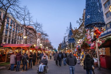 Duisburg Noel Pazarı 'nda (Weihnachtsmarkt), Işıklar, Dükkanlar ve Alışverişçiler ile birlikte bir Neşeli Atmosferin Panoraması. Duisburg Noel pazarı Almanya 'nın en eski pazarlarından biridir.