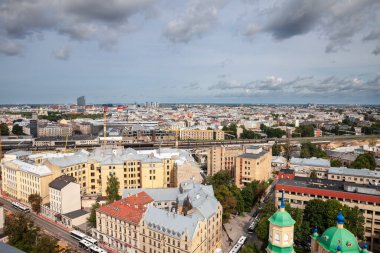 RIGA, LATVIA - 25 AĞUSTOS 2023: Riga merkezinin havadan manzarası, yerleşim binaları ve arka plandaki eski şehir. Riga Letonya 'nın başkentidir..