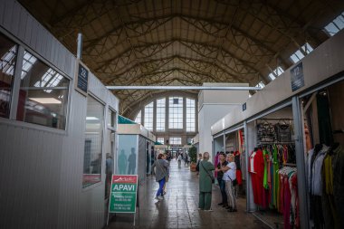 RIGA, LATVIA - 23 AĞUSTOS 2023: İnsanlar, satıcılar, Centraltirgus, Riga Merkez Pazarı 'ndaki bir pavyonda müşterilerle görüşmeler, bir dönüm noktası ve Letonya ekonomisinin sembolü.