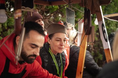 RUMENKA, SERBIA - FEBRUARY 12, 2024: Serbian Woman wearing a Traditional Sajkaca Hat. Sajkaca is a traditional serbian hat, usually used by men only. clipart