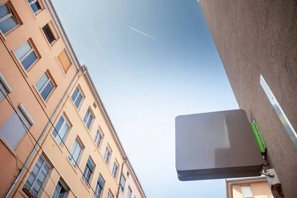 stock image Selective blur on a Empty grey square shop signboard hanging on a building facade, visible against a clear sky in a French city street ideal for retail business advertising & urban commercial display.