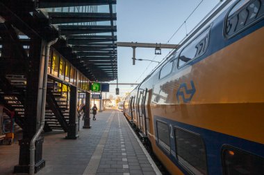 HEERLEN, NETHERLANDS - 10 Kasım 2022: Heerlen tren istasyonundaki Nederladse Spoorwegen 'in çift katlı bölgesel treninde seçici bulanıklık.