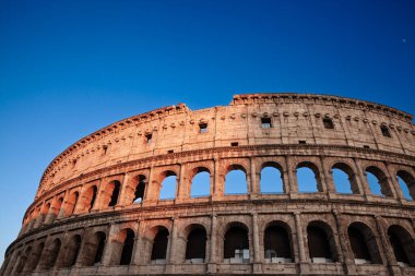 Roma 'daki Kolezyum, İtalya' da Roma mühendisliğinin ve antik Roma 'nın sembolü olan tarihi mimarisini ve anıtsal taş kemerlerini sergiliyor..