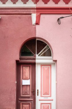 İki taraf arasında bir zıtlık gösteren bir Sırp evinin giriş kapısı görüntüsü. Fotoğraf, dış görünüşün mimari ayrıntılarını ve renk farklılıklarını yakalar, kentsel yerleşim tasarımı yansıtır..
