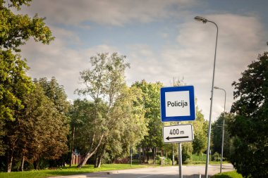 Road sign indicating the nearest police station in Latvia, with 'Policija' meaning police in Latvian. clipart