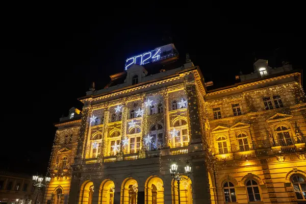 stock image NOVI SAD, SERBIA - DECEMBER 12, 2022: Selective blur on Novi Sad City Hall illuminated for Christmas and New Year 2024 at night. Also called gradska kuca, it's a major landmark of Novi Sad.