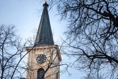 Selective blur on the Church clocktower steeple of the Serbian Roman Catholic Church of Crkva Svetog Karla Boromejskog, also called Church of Saint Carlo Borromeo in Pancevo, Vojvodina. clipart