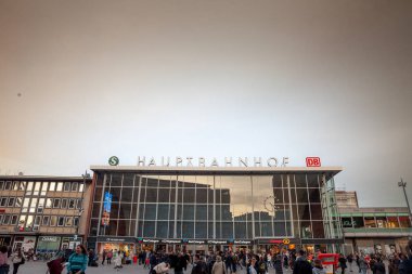 KOLOGNE, GERMANY - 6 NOVEMBER 2022: Köln Hbf 'ün ana cephesi, veya Köln Ana Tren İstasyonu (Hauptbahnhof) alacakaranlıkta yolcuların aceleyle koştuğu ana tren istasyonu..