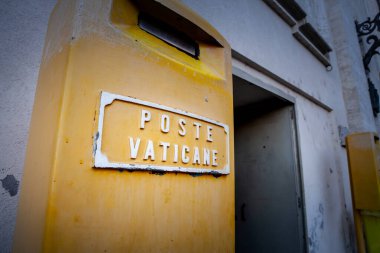 VATICAN - 15 Haziran 2024: Vatikan 'ın tarihi posta hizmetini ve Vatikan' ın posta sistemini temsil eden sarı bir posta kutusunun üzerindeki Vatikan logosu.
