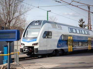 Bir tren istasyonunda yakalanan ve bölgesel ve banliyö trafiği için tasarlanmış modern çift katlı elektrikli çoklu tren (EMU). Trende etkin yolcu taşımacılığı için gelişmiş teknoloji yer almaktadır..