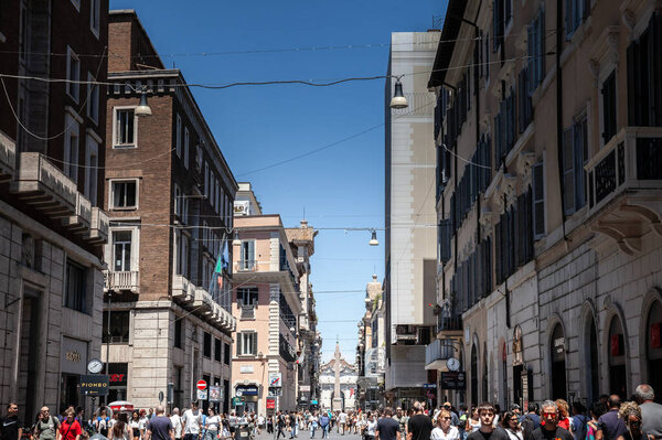 ROME, ITALY - JUNE 15, 2024: Busy Via del Corso in Rome, Italy, a popular shopping street with stores & filled with people. This high street is a hub for retail and commerce, reflecting urban economy.
