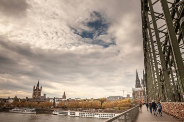 COLOGNE, GERMANY - NOVEMBER 6, 2022: Panorama of the center of Cologne, with the iconic hohenzollern bridge, or hohenzollernbrucke, a railway bridge, and the Cologne cathedral in background.