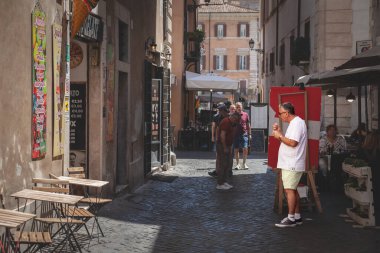 ROME, ITALY - 15 HAZİRAN 2024: seçici bulanıklık bir turist, bir adam, dondurma yiyor, İtalya 'nın göbeğinde bir İtalyan dondurması yiyor. İtalyan dondurması İtalyan mutfağının bir geleneğidir..
