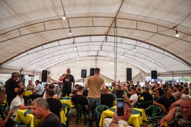RUMA, SERBIA - 18 Haziran 2024: Ruma, Serbia 'da bir Sırp şarkıcı, geleneksel Sırp restoranı ve barında şarkı söyleyen, mutlu ve kutlama yapan bir adam hakkında seçici bulanıklık.