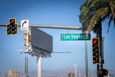 Las Vegas Bulvarı 'ndaki (Las Vegas Bulvarı) tipik bir Amerikan kavşağı, trafik ışıkları, yol işaretleri ve palmiye ağaçları, Las Vegas, Nevada' nın kentsel manzarasını sembolize eder..