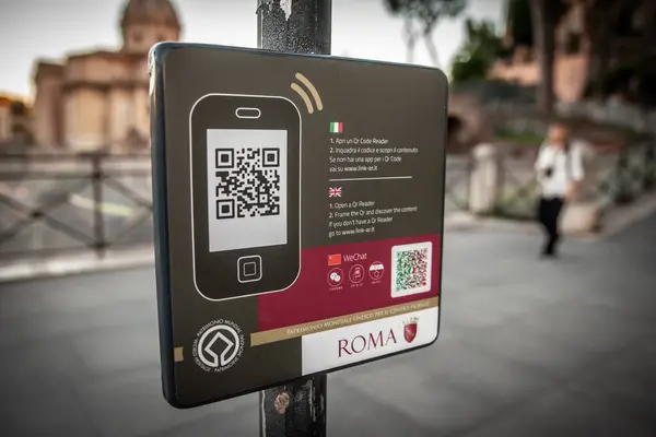 Stock image ROME, ITALY - JUNE 15, 2024: A sign in Rome encourages tourists to download a smartphone guide via a QR code. The sign represents the integration of modern technology into tourism, providing convenient information access.