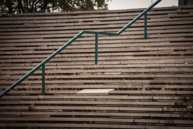 Eski & harap basamaklardaki seçici bulanıklık kentsel bozulmayı gösteriyor. Yıpranmış merdivenler ihmal ve zamanın geçişini, yaşlanma altyapısı ile ilgili sorunları ve kentsel yenileme potansiyelini yansıtıyor.