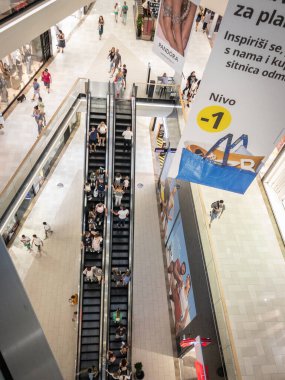 NOVI SAD, SERBIA - SEPTEMBER 12, 2024: escalator inside Promenada Mall in Novi Sad. The architecture of shopping center showcases interior design elements, offering contemporary shopping experience. clipart