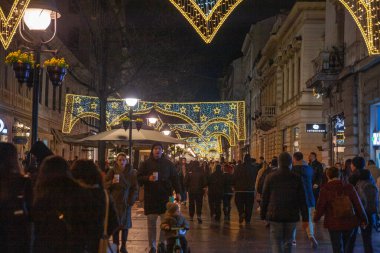 BELGRAD, SERBIA - 11 Aralık 2023: Kneza Mihailova caddesinde eski kasaba dekorasyonu ve yılbaşı için aydınlatılmış kalabalık yürüyüşü. Işıklar neşeli bir atmosfer yaratıyor..