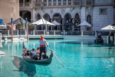 LAS VEGAS, AUGUST 21, 2024: gondola floats in The Venetian Las Vegas, a luxury resort replicating the canals and architecture of Venice, Italy. The scene showcases the themed attractions of Las Vegas. clipart