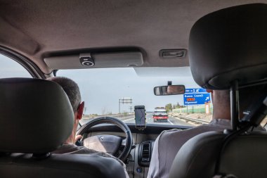 VALENCIA, İspanya - 13 Ekim 2024: İnsanlar Valencia yakınlarındaki bir İspanyol otoyolunda İspanyol otoyollarının altyapısını gösteren GPS navigasyon sistemini kullanarak araba kullanıyorlar.