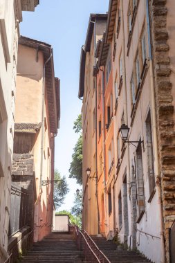 Along the Montee des Carmes Dechausses in Vieux Lyon, a steep staircase leads upward through centuries of history. Flanked by pastel-hued buildings, time-worn stones, and delicate architectural details, this narrow lane embodies the spirit of a city  clipart