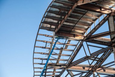 Çelik çerçeveli bir bina Las Vegas 'ta bir inşaat sahasında yükseliyor. Ağır ekipmanlar ve kısmi çatı bölümleri devam eden şehir gelişimini ve ABD ticari genişlemesini vurguluyor