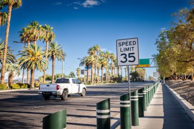 Las Vegas 'ta palmiye çizgili bir şehir yolu boyunca 35 mil hız sınırı tabelası var. Güneşli çöl sahnesi, güneybatı ortamında tipik Amerikan sürüş kurallarının altını çizmektedir..