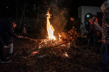 BELGRAD, SERBIA - 6 Ocak 2025: Ortodoks noeli sırasında Belgrad 'ın Banjica kentinde badnjak şubelerini yakan Sırp Halkı hakkında seçici bulanıklık. Bu geleneksel bir Sırp Noel geleneğidir..