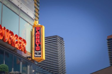 LAS VEGAS, AUGUST 18, 2024: A vibrant Parrys Pizzeria & Taphouse sign stands out against sleek high-rises in las Vegas. parry s pizza is a chain of restaurants specialized in new york pizza clipart