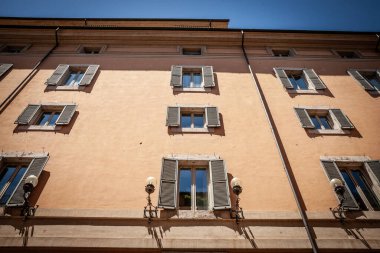 Roma, İtalya 'nın tarihi kesimindeki eski konut binasının cephesi. Görüntüde geleneksel mimari öğeler, pencereler ve balkonlar, Roma mimarisi ve kentin kent karakteri yer alıyor..