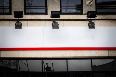 Belçika 'da bir ofis cephesinde boş beyaz dikdörtgen tabela. Şık, modern tasarım taşın dış görünüşünü tamamlıyor, kentsel bir ortamda kurumsal mesajlar için çok yönlü bir marka yüzeyi sağlıyor..