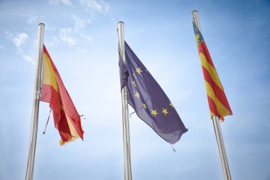 İspanya, Avrupa Birliği ve Comunidad Valencianaflutter 'ın üç bayrağı, açık gökyüzüne karşı kültürel birlik ve bölgesel gururu temsil ediyor. İspanya, Avrupa Birliği üyesidir.