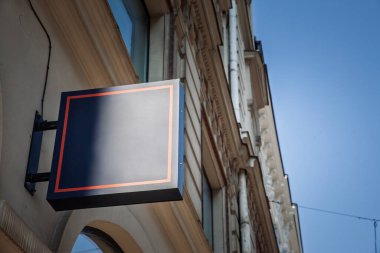 Letonya 'da bir mağazanın önünde boş mavi kare işareti, özel markalaşma veya reklam metni eklemek için uygun.